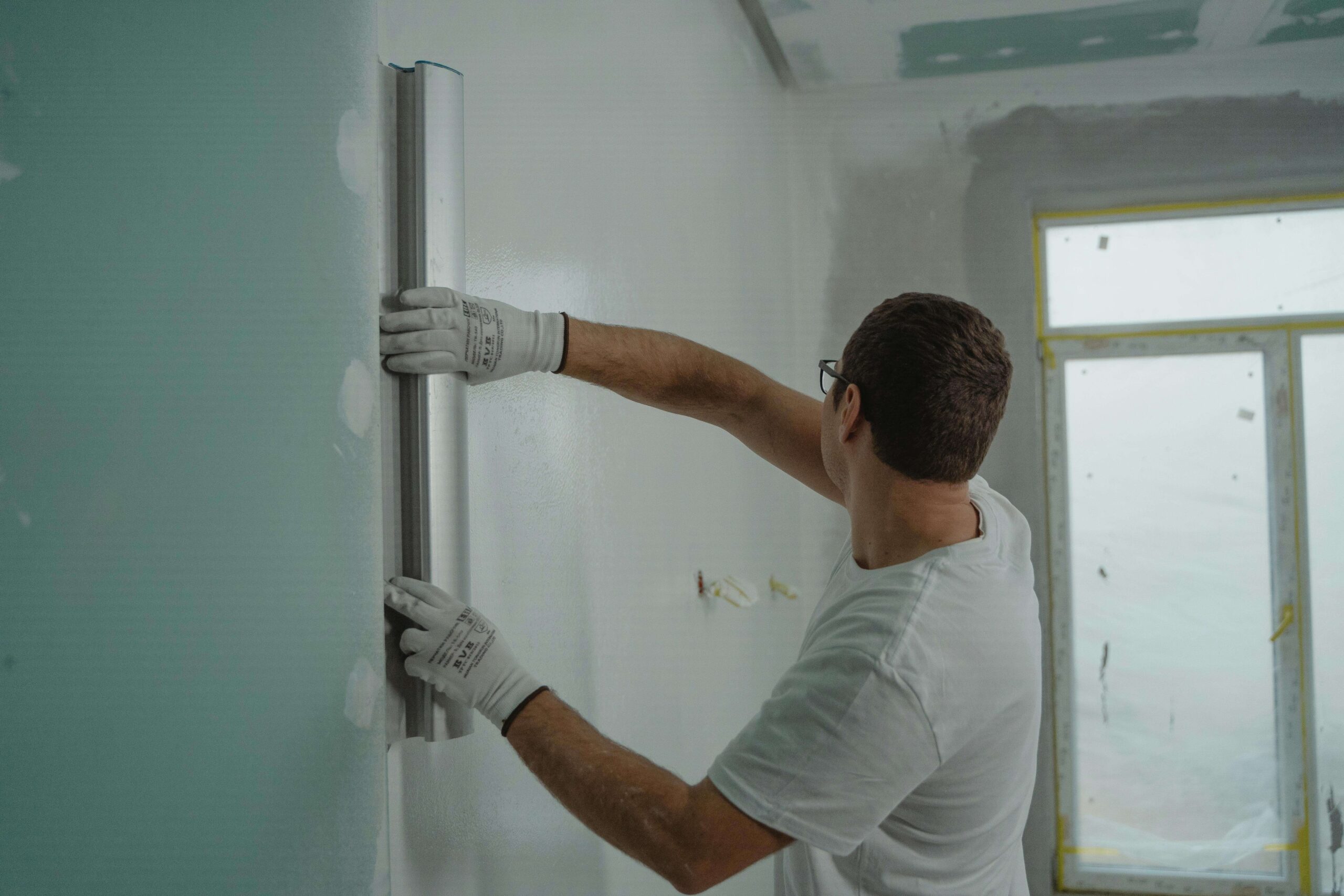 a man in white shirt painting a house
